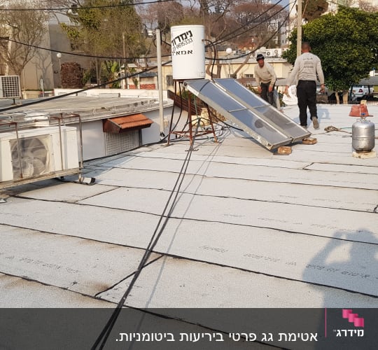עובדים מבצעים איטום גג עם יריעות ביטומניות